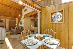 Un comedor con interior de madera, una mesa de vidrio y una obra de arte enmarcada en la pared.