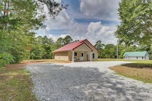 A single-story building with a red roof, a gravel driveway, and a green lawn. - Hunt & Fish! Home < 1 Mi to Broad River Campground (Tignall)