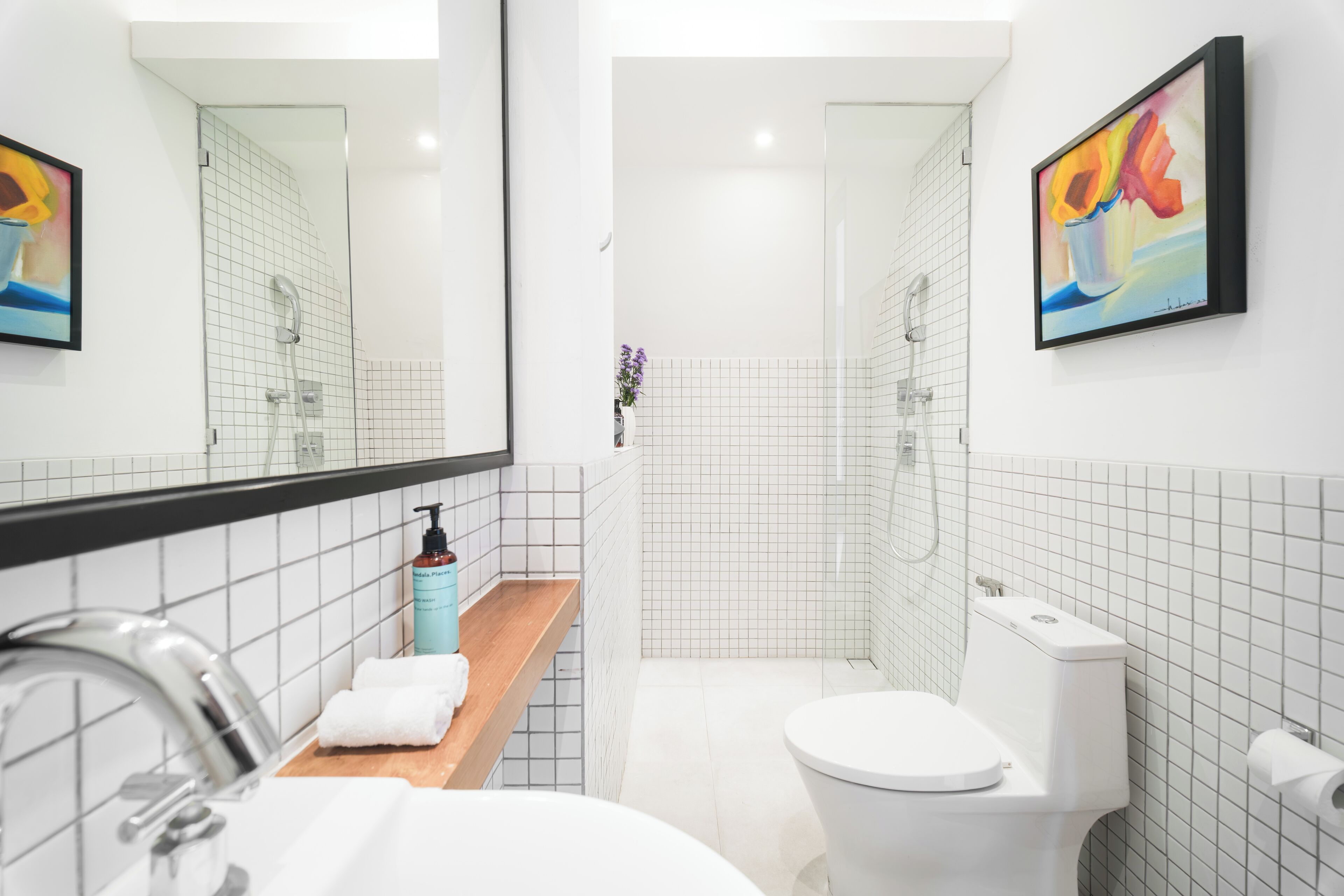 A modern bathroom with a sink, mirror, toilet, and shower.