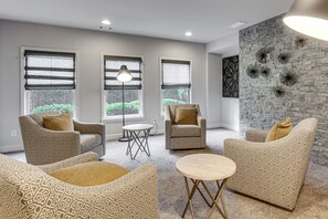 A modern living room with patterned furniture, a round coffee table, and a decorative wall. - Executive 5BR Stay in Duluth w/ Pool Access (Duluth)