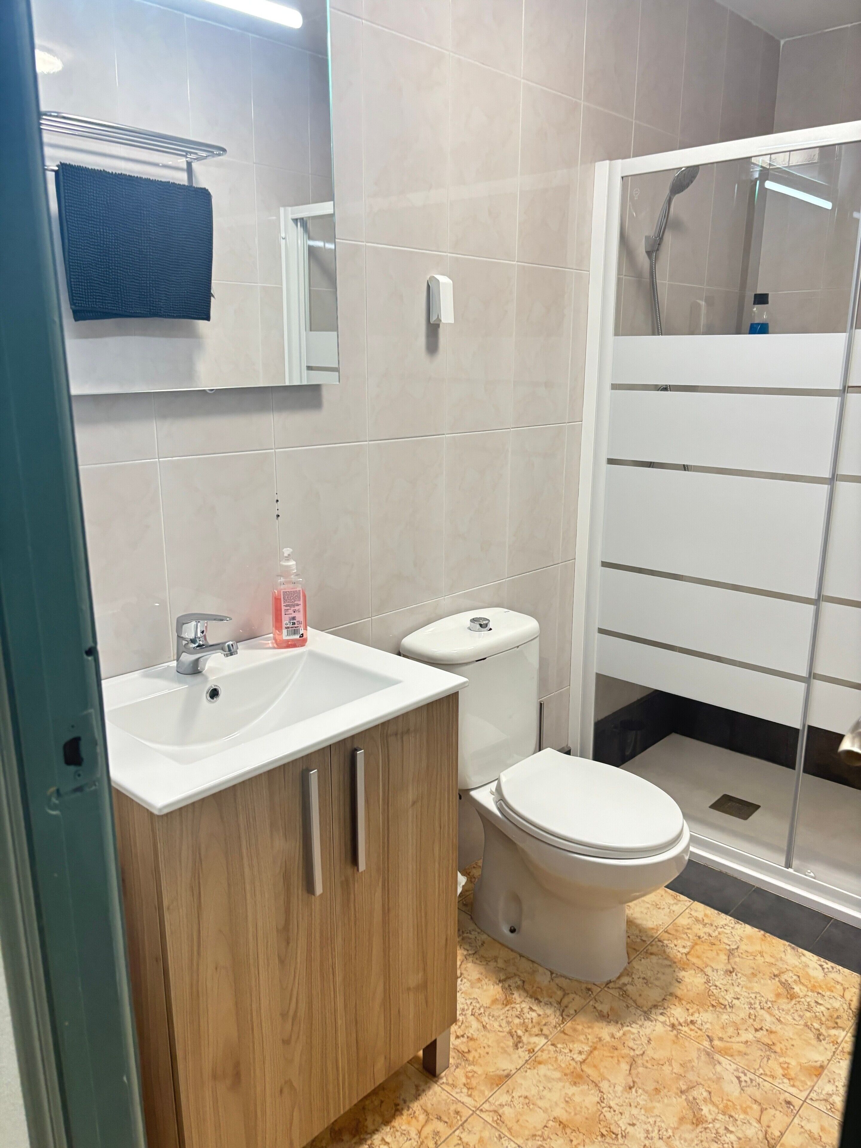 Ein Badezimmer mit Waschbecken, Toilette und Duschbereich.