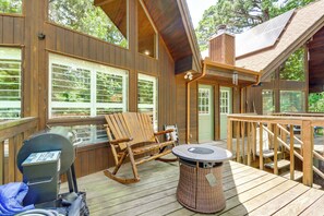 A wooden deck with a rocking chair, a round table, and a grill. - 6 Mi to Eureka Springs! Home By Table Rock Lake (Holiday Island)