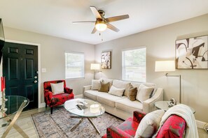 A living room with a ceiling fan, a sofa, a coffee table, and a chair.