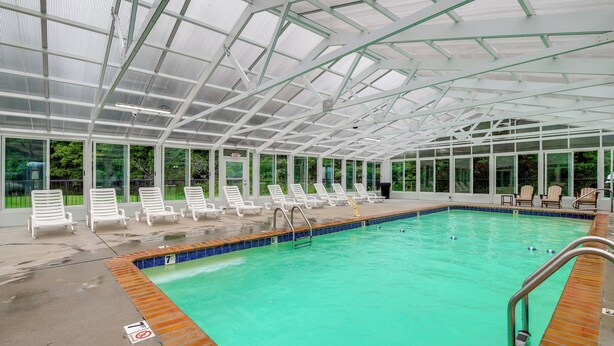 En pool med tak, solstolar och en utrymningsskylt.