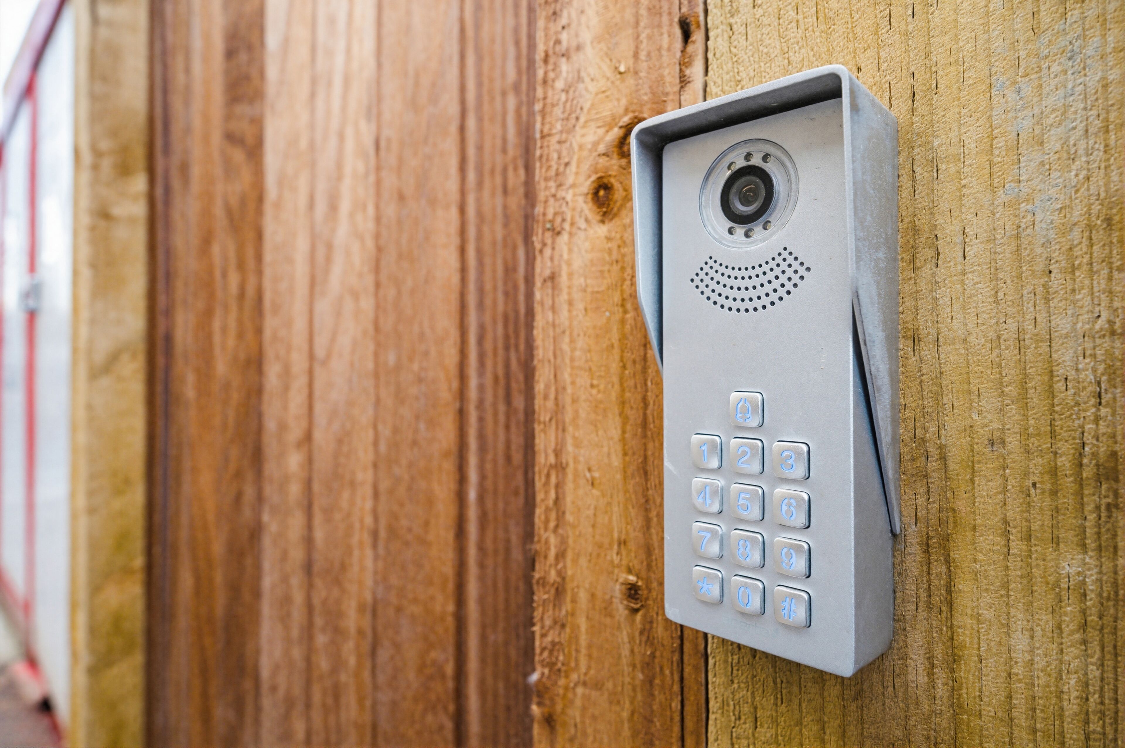 A security keypad mounted on a wooden surface.