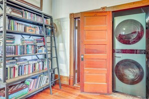 Ein Zimmer mit Bücherregal, Holztür und Waschmaschine.