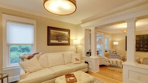 Een woonkamer met een beige bank, een salontafel en een inlijste kaart aan de muur.