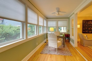 A room with large windows, a ceiling fan, a dining table with chairs, and a side table with a lamp. - 'The Hand House!' Walk to Downtown & Race Course (Saratoga Springs)