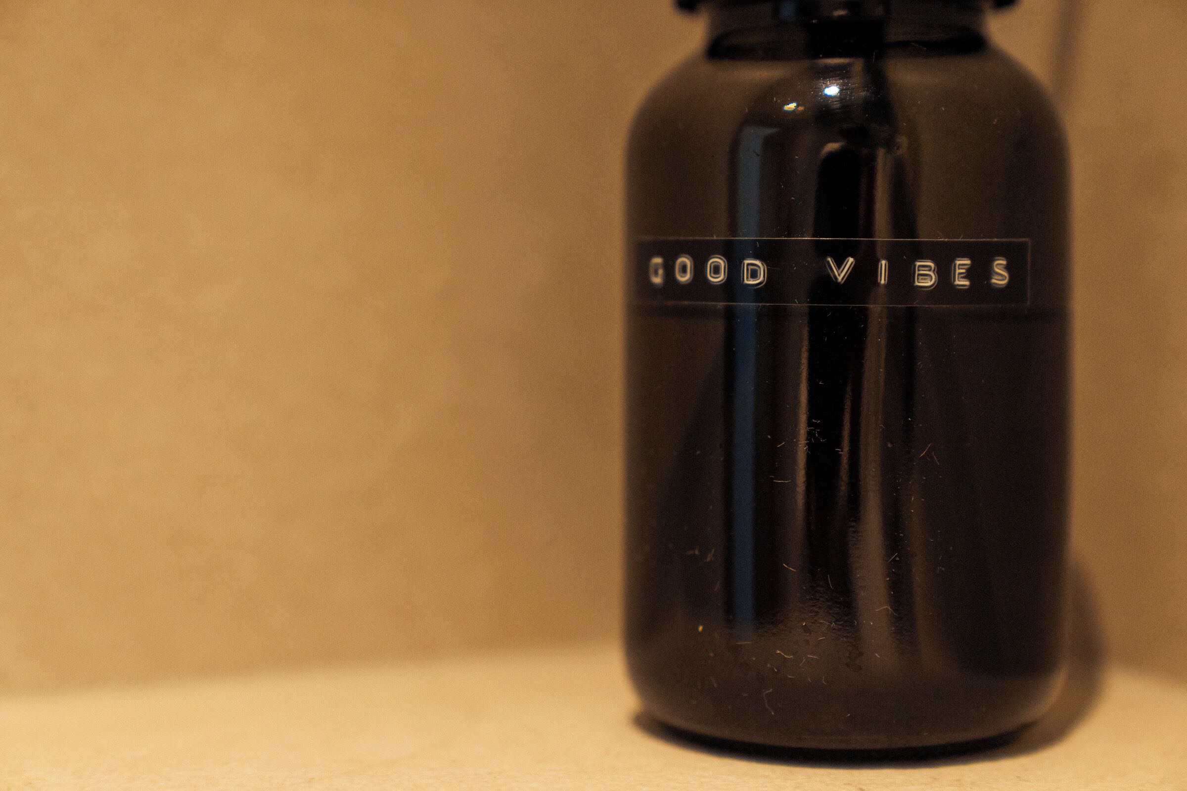 Een zwarte fles met de tekst 'GOOD VIBES' erop.