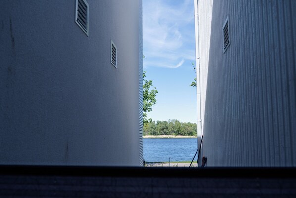 A view through a window with a clear sky and a body of water in the distance.