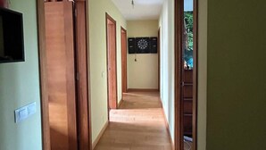 A hallway with wooden doors, a dartboard, and a light fixture.