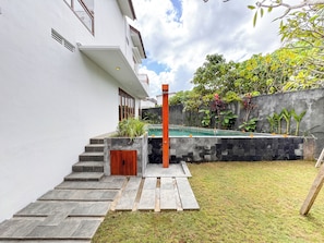 A modern house with a swimming pool, a stone staircase, and a garden with various plants. - Villa Amaya Canggu by Nagisa Bali (Badung)