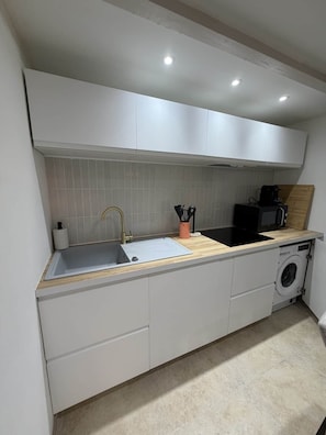 A compact kitchen with a sink, a coffee machine, and a washing machine. - Le Petit Venard | Private parking | Private terrace (Vieux-Boucau-les-Bains)