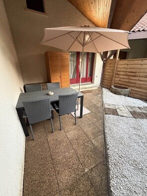 An outdoor patio with a table and chairs, a wooden ceiling, and a gravel area. - Le Petit Venard | Private parking | Private terrace (Vieux-Boucau-les-Bains)