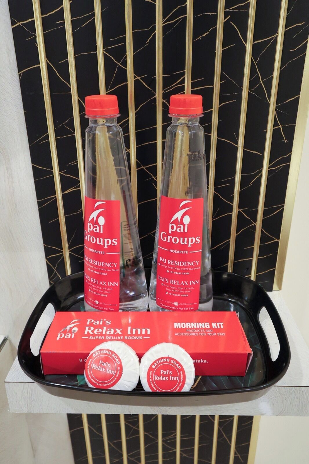A tray with two bottles of 'Pai's Relax Inn' products, a red box labeled 'Pai's Relax Inn,' and two round soap bars.