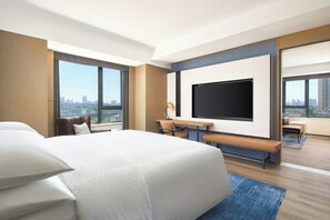 A modern hotel room with a large bed, a flat-screen TV, a desk with a chair, and a view of the cityscape. - Four Points by Sheraton Nanjing, Gulou District (Nanjing)