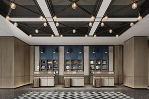 Un intérieur moderne avec un plafond au design géométrique, des étagères intégrées ornées d’objets décoratifs et un motif de carreaux sur le sol.