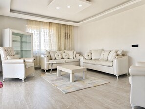 Una sala moderna con un conjunto de sofá, una mesa de centro y un aparador de vidrio.