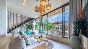 Ein modernes Wohnzimmer mit Sofa, Couchtisch und Blick ins Freie.