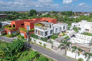 Un moderno edificio residencial de varios niveles, con grandes ventanales y techo plano.