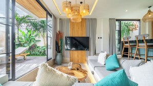 Ein modernes Wohnzimmer mit einer Couch, einem Fernseher und einem Essbereich.