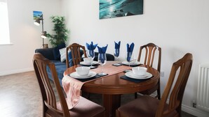 Comedor con una mesa redonda dispuesta para cuatro personas, rodeada de sillas de madera.
