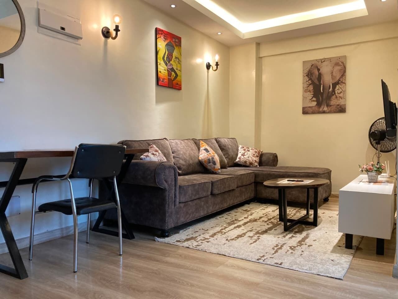 Una sala moderna con un sofá, una mesa de comedor y una mesa de centro.