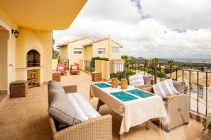 A terrace with wicker furniture, a pool table, and a view of the landscape. - La Manga Club Monte Verde Apartment 618 (Cartagena)
