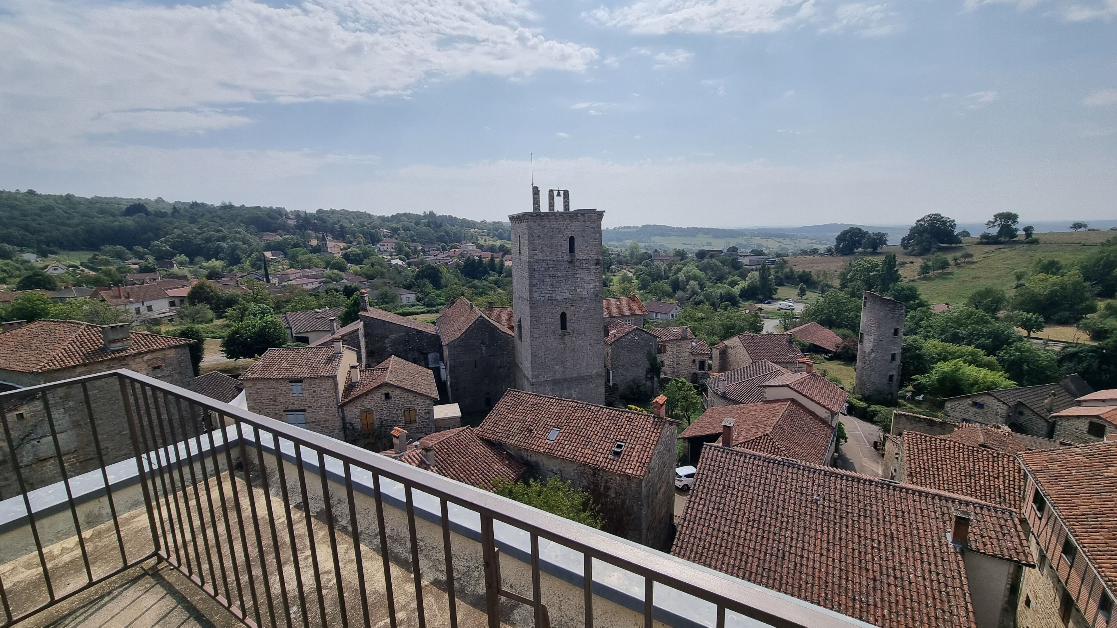 A view of a town with stone buildings and a prominent tower.