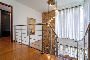 Ein modernes Interieur mit Holzboden, einer Metalltreppe und einer Ziegelwand als Blickfang.