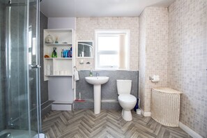 A bathroom with a shower, sink, toilet, and a window. - Albert Edward House – Modern 2BR Home in Liverpool (Liverpool)