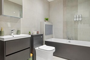 Ein modernes Badezimmer mit einer Badewanne, Toilette und Waschbecken.