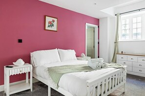 A bedroom with a bed, white nightstands, a dresser, a mirror, and a window with curtains. - Prime 2BR Apt Overlooking Old Market Square (Nottingham)