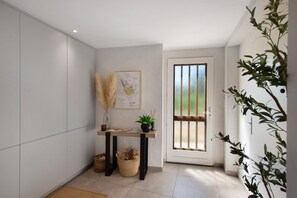 A modern kitchen with white cabinets, a wooden table with a map, and a door leading outside.