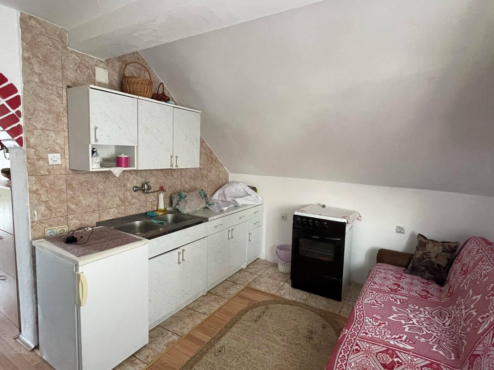 Une cuisine de taille réduite comprenant un évier, des placards, un réfrigérateur et une cuisinière.