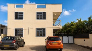 A two-story building with a flat roof, multiple windows, and a paved driveway.