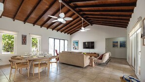 Amplia sala de estar con mesa de comedor, sofás y televisor.