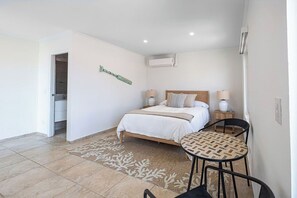 Ein Schlafzimmer mit einem Bett, Nachttischen, einem Sessel und einem Teppich.