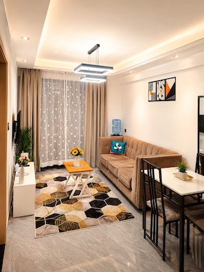 Ein modernes Wohnzimmer mit Sofa, Couchtisch und Essbereich.