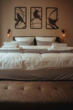 A bed with white linens, a brown headboard, and two wall-mounted light fixtures. - City Apartment I Free Parking (Bielefeld)