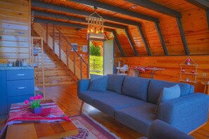 Un interior de madera con sofá, una mesa de comedor y una escalera.