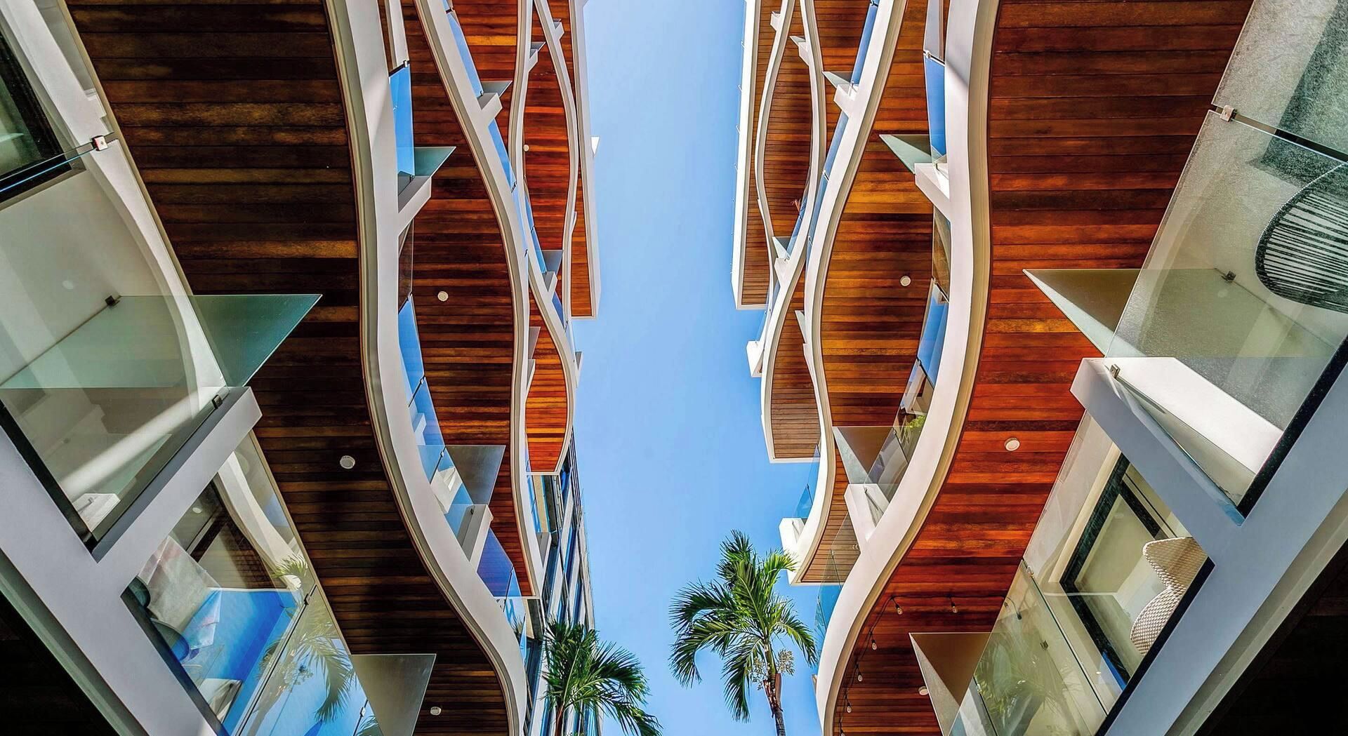Ein modernes Gebäude mit einzigartigem architektonischem Design, das gewölbte Balkone und Holzverkleidungen aufweist.