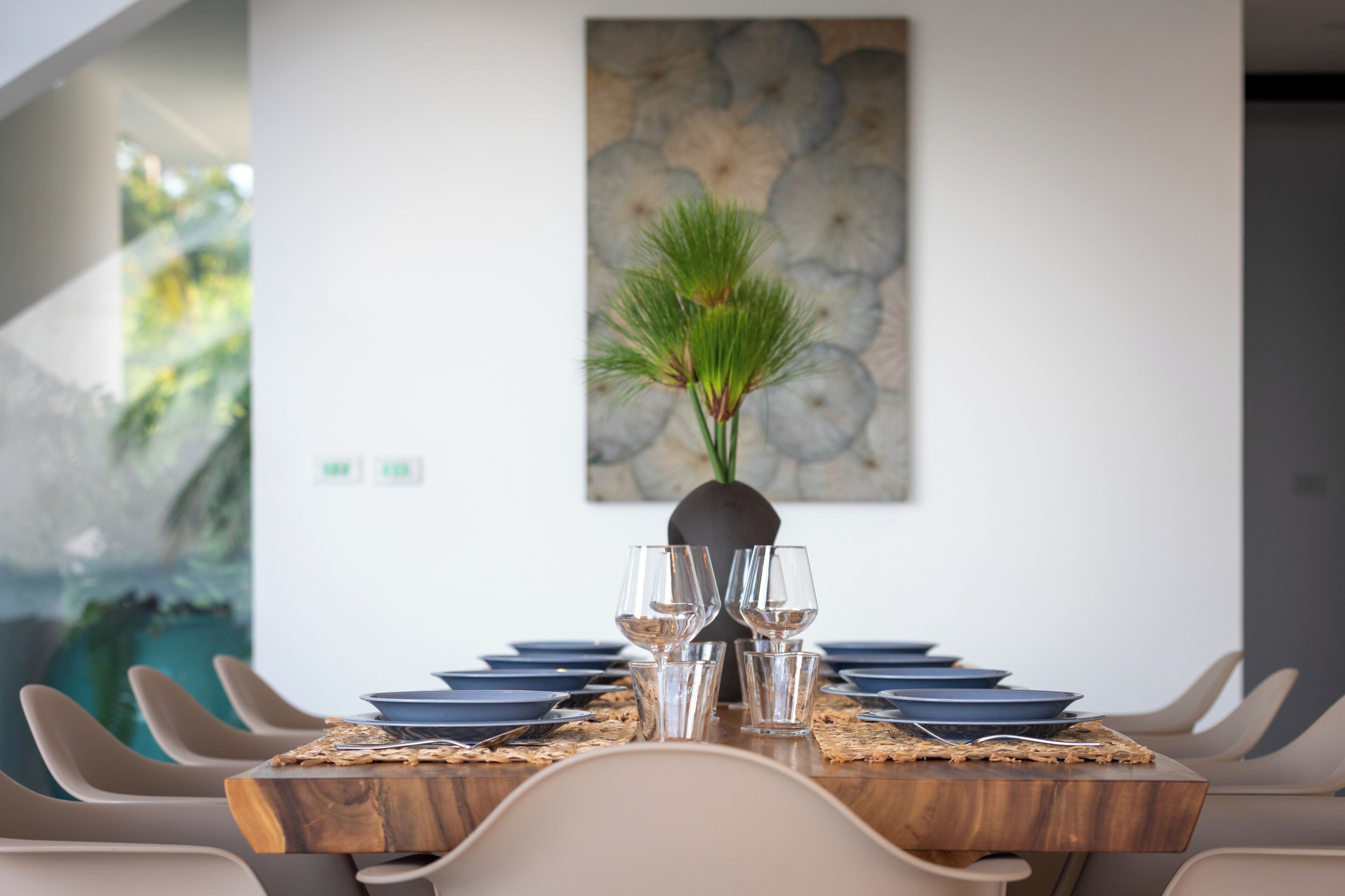 A dining table set with plates, glasses, and a centerpiece.