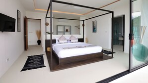 A modern bedroom with a four-poster bed, a flat-screen TV, and a large mirror.