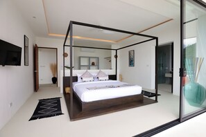 A modern bedroom with a four-poster bed, a flat-screen TV, and a large mirror. - 4 Bedroom Seaview Tropical Eco-friendly Villa (Koh Samui)