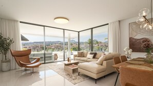 Una sala de estar moderna con un sofá, sillones, una mesa de centro y un comedor con mesa y sillas.