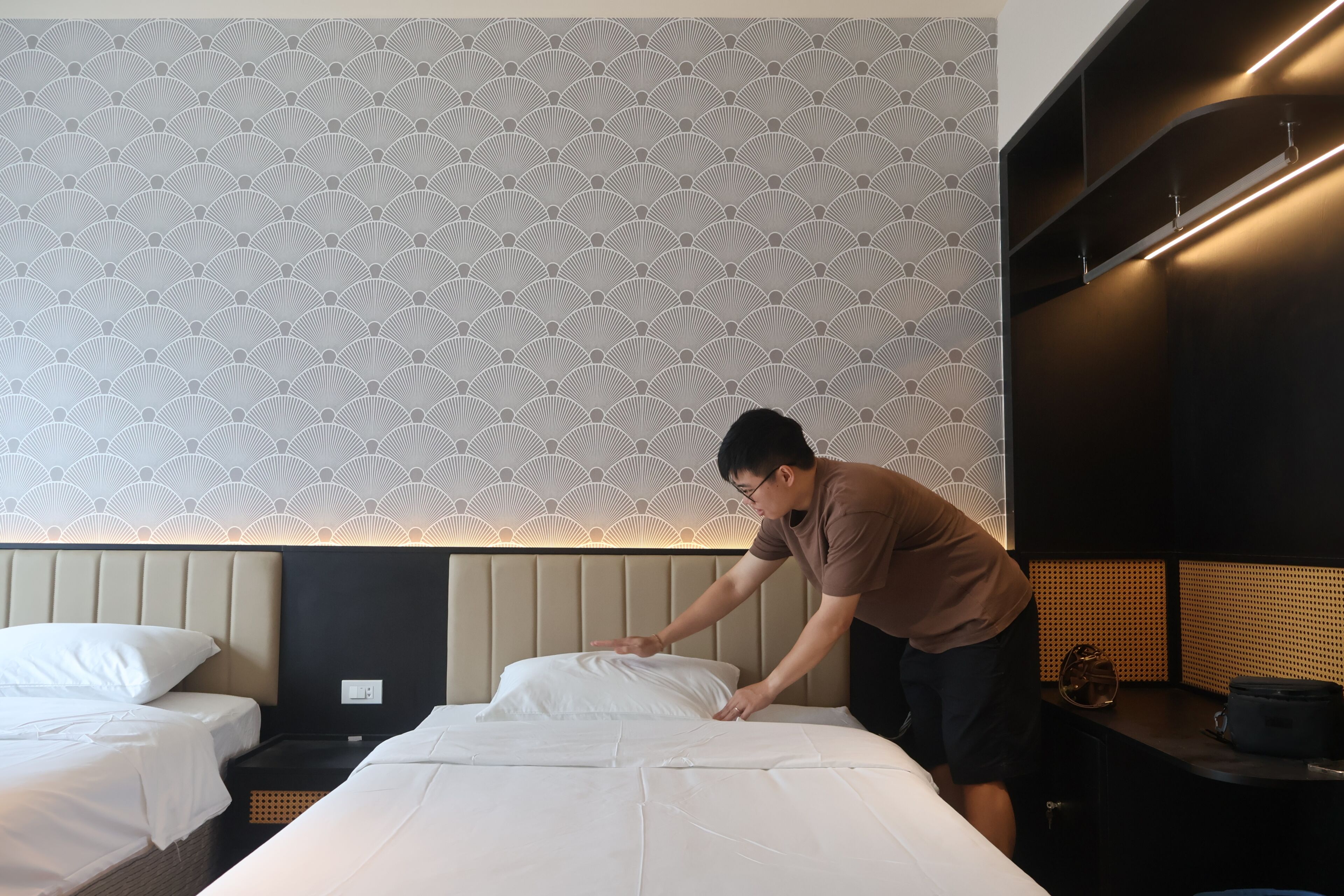Ein Hotelzimmer mit einem Bett, einer Kommode und einer Wand mit geometrischem Muster.