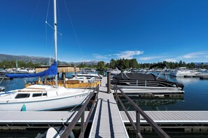 Ein Yachthafen mit vertäuten Booten, eine Holzsteg und ein klarer, blauer Himmel.