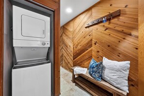A room with a white appliance, a wooden bench with pillows, and a wooden wall with a mounted shelf. - Private Boat Dock + BBQ Patio | Tahoe Keys Waterfront | Dock & Pine (South Lake Tahoe)