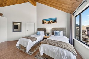 A hotel room with two beds, a large window, a painting on the wall, and a wooden ceiling. - Private Boat Dock + BBQ Patio | Tahoe Keys Waterfront | Dock & Pine (South Lake Tahoe)
